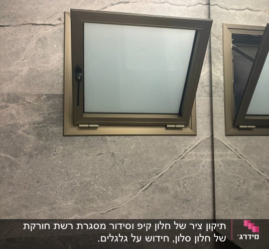 חלון קטן עם מסגרת אלומיניום על קיר שיש אפור